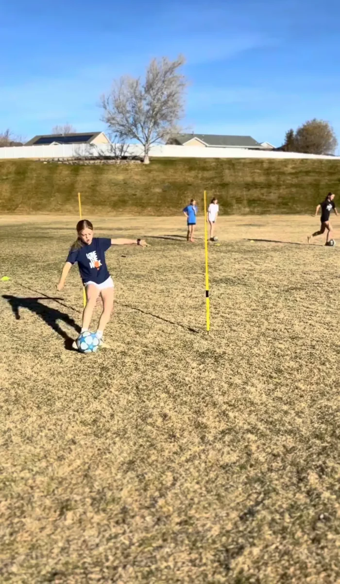 Young athlete dribbling through cones